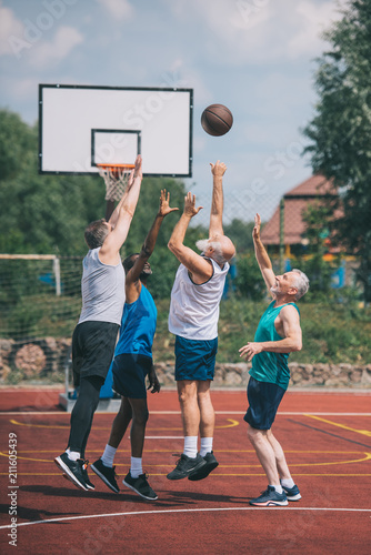 interracial elderly sportsmen playing basketball together on playground © LIGHTFIELD STUDIOS