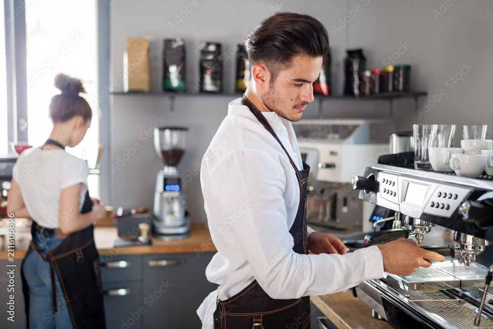 Barista preparing coffee using machine in the cafe