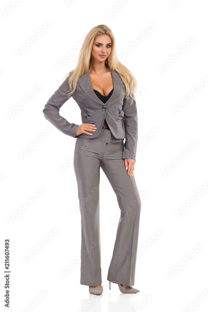 Beautiful Woman In Gray Suit Is Standing With Hand On Hip Beautiful Woman In Gray Suit Is Standing With Hand On Hip