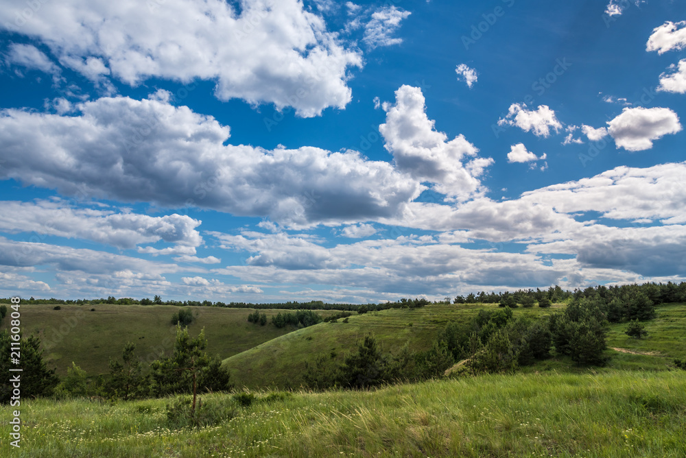 Beautiful summer landscape - hills and beautiful blue sky with clouds on the horizon