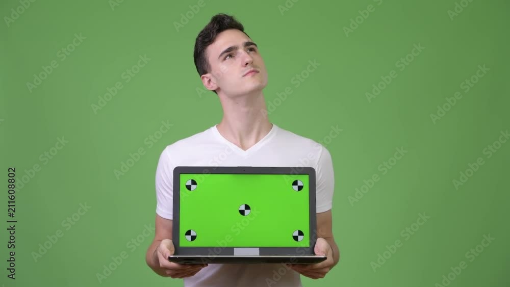 Young handsome man thinking while showing laptop Young handsome man thinking while showing laptop