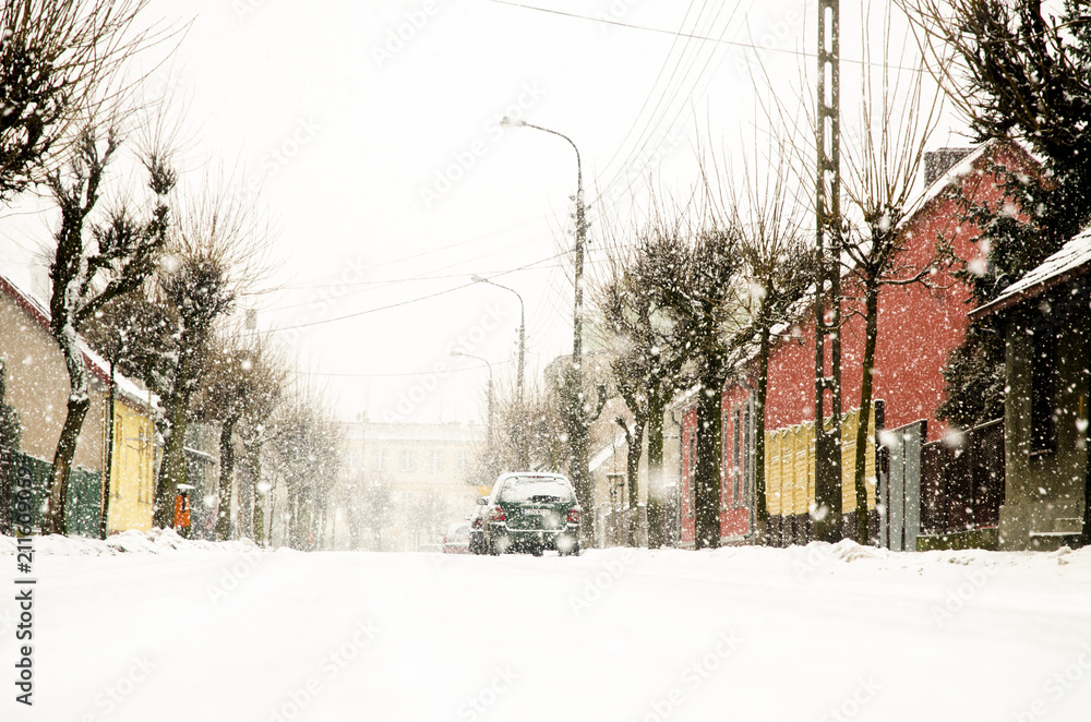Naklejka premium A street in the town when snow falls. A dazzling landscape with available space at the bottom
