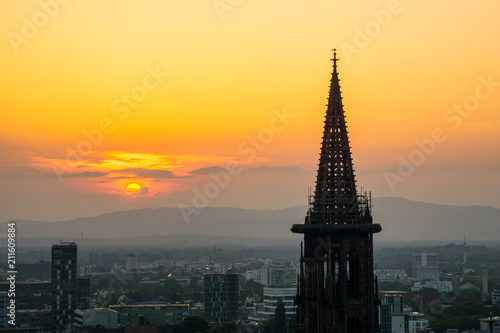 Germany, Minster of Freiburg im Breisgau under orange glowing sky
