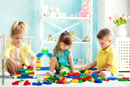 Children playing at home on the floor with cubes