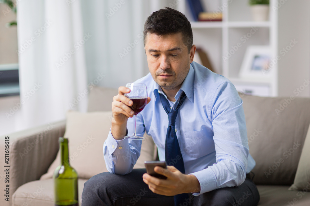 alcoholism, alcohol addiction and people concept - drunk man with smartphone and bottle of wine at home alcoholism, alcohol addiction and people concept - drunk man with smartphone and bottle of wine at home