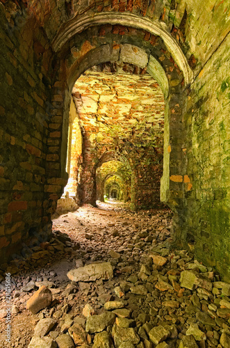 Very long corridor with many arches. Abandoned Tarakaniv Fort in the summer day. Tarakaniv, Rivne oblast, Ukraine