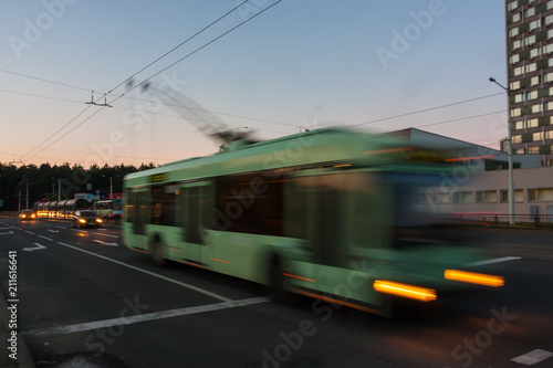 Movement of a blurred trolleybus at dusk along the street. © leon134865