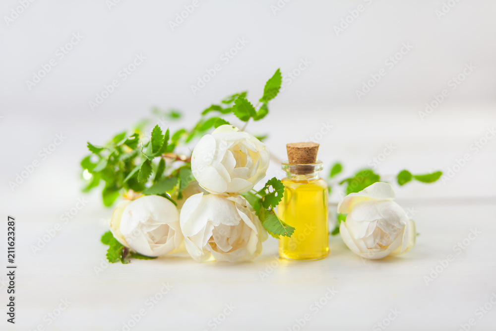 Essence of flowers on white background in beautiful glass jar