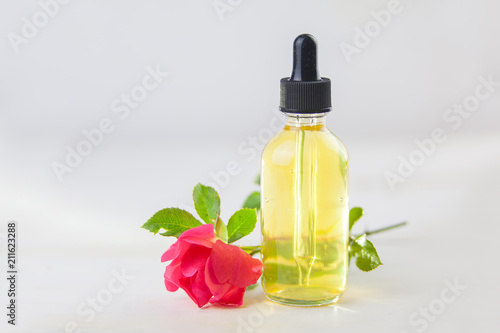 Essence of rose on White background in beautiful glass bottle
