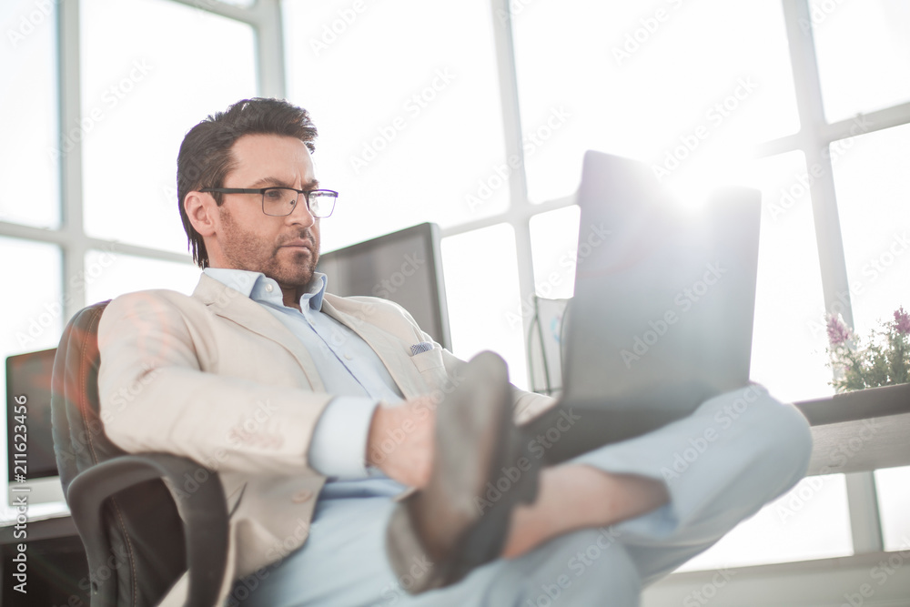 businessman using a laptop sitting at his Desk businessman using a laptop sitting at his Desk