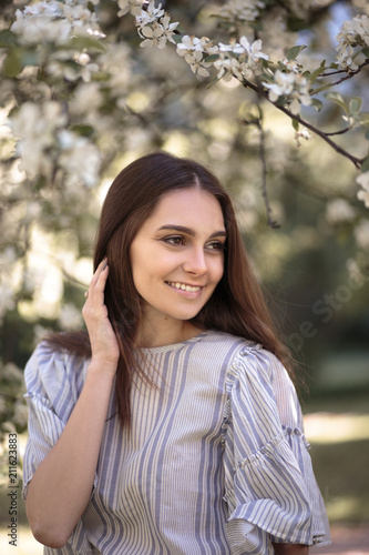 Pretty young woman in a summer garden, casual romantic style with hat