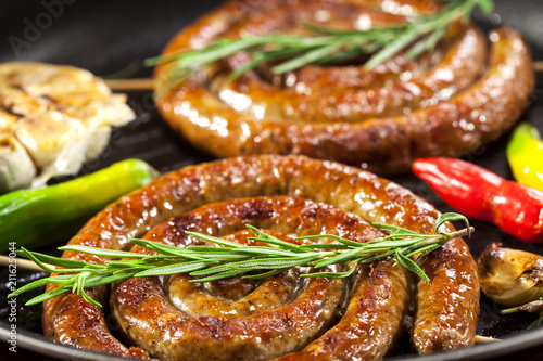 Grilled spiral sausages in a pan photo