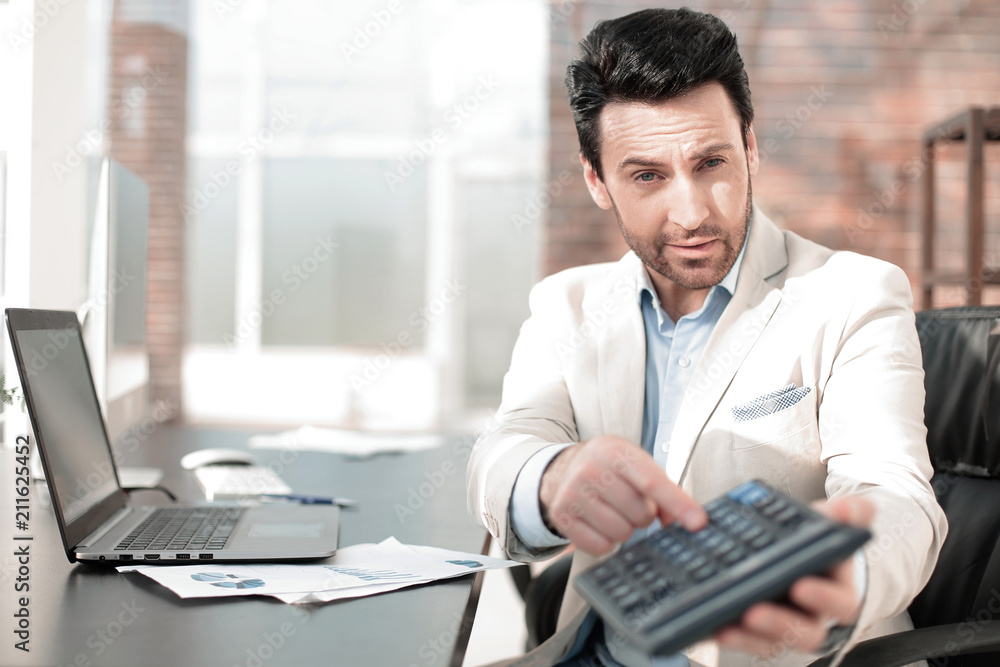 Businessman pointing to calculator in hand. Businessman pointing to calculator in hand.