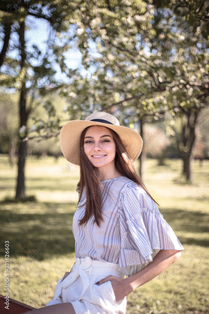 Pretty young woman in a summer garden, casual romantic style with hat Pretty young woman in a summer garden, casual romantic style with hat