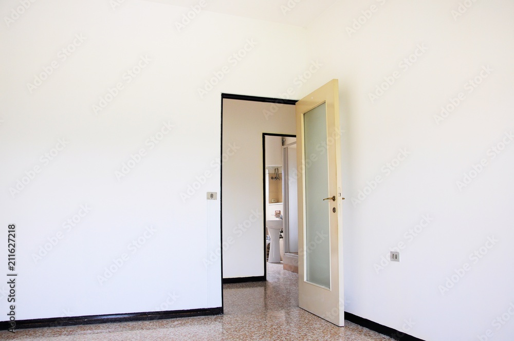 Interior of empty white room with two doors to toilets. Interior of empty white room with two doors to toilets.