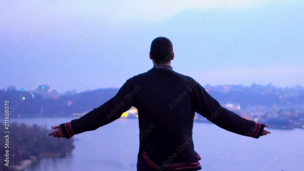 Man raises hands to sky, feels strength and self-confidence to conquer world Man raises hands to sky, feels strength and self-confidence to conquer world