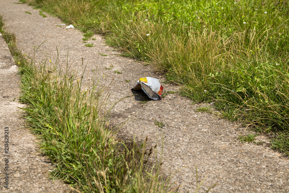 Thrown plastic bag on the road going through the park Thrown plastic bag on the road going through the park