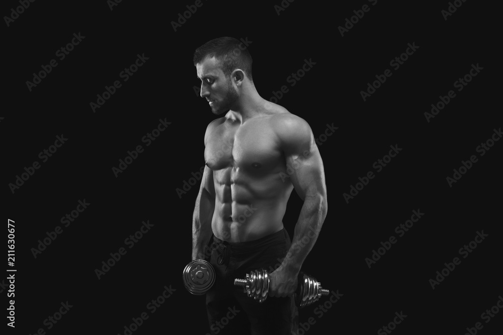 Fototapeta premium Strong man with dumbbell showing muscular body