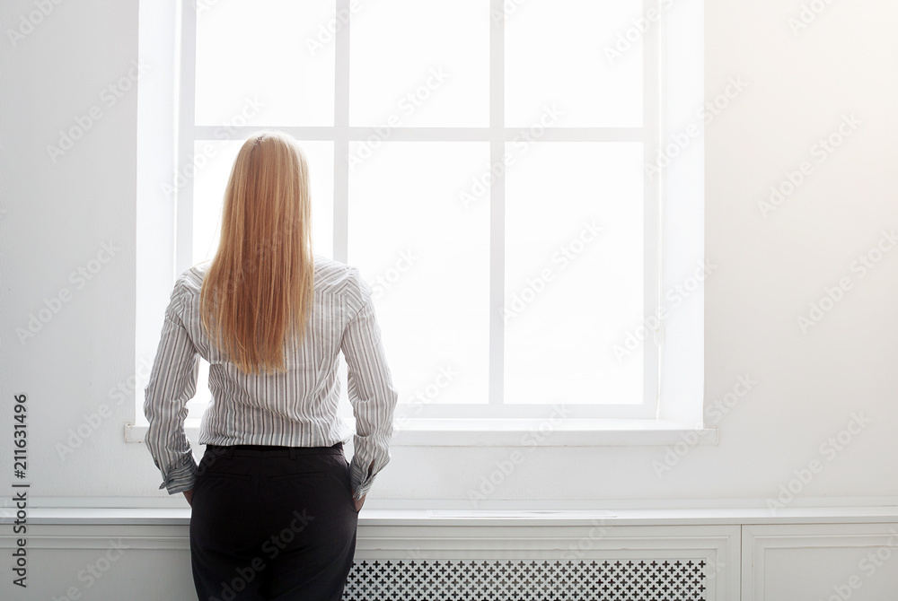 Back view of young boss standing at the window Back view of young boss standing at the window