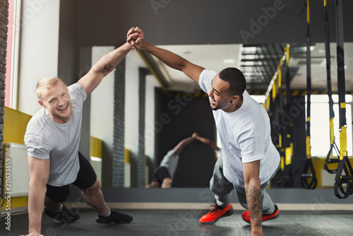 Two happy men fitness workout together at gym