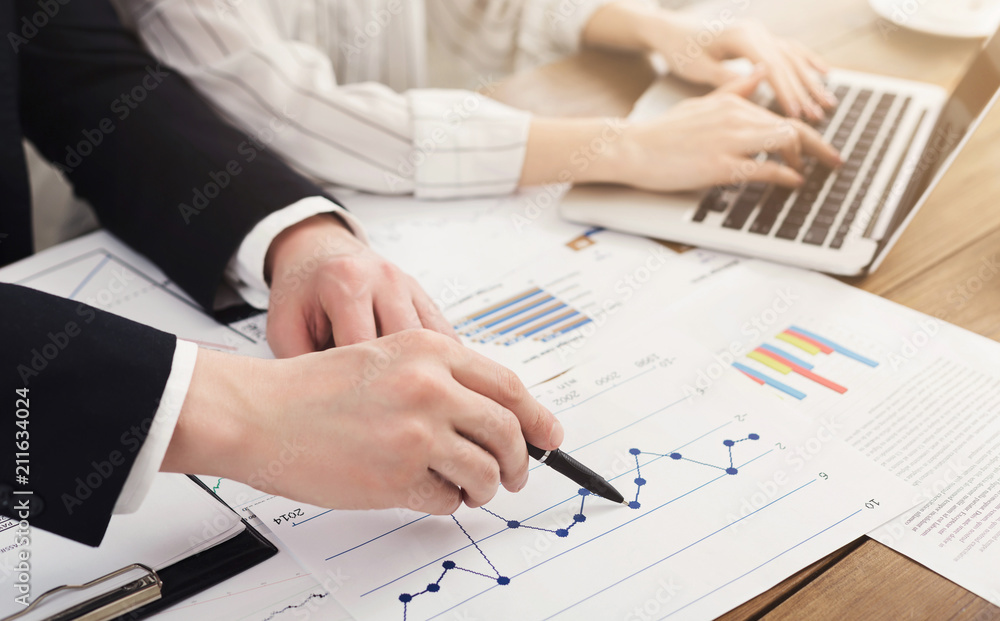 Man and woman analyzing financial graphs Man and woman analyzing financial graphs
