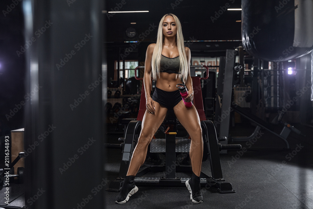 beautiful girl bodybuilder , execute exercise with dumbbells, in dark gym beautiful girl bodybuilder , execute exercise with dumbbells, in dark gym