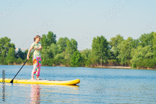Woman sails on a SUP board in large river
