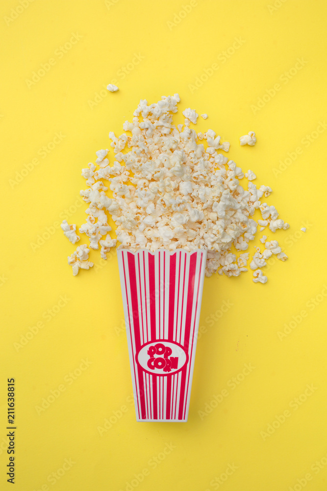 Container full of popcorn on yellow