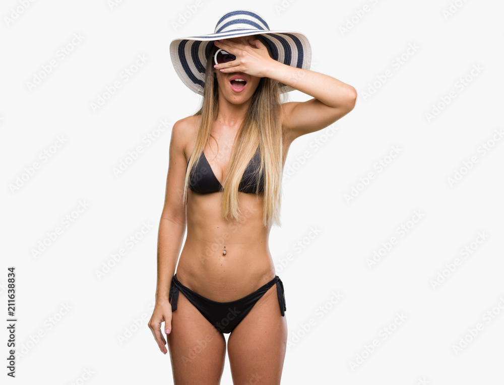 Beautiful young woman wearing bikini, sunglasses and hat peeking in shock  covering face and eyes with hand, looking through fingers with embarrassed  expression. Stock Photo | Adobe Stock