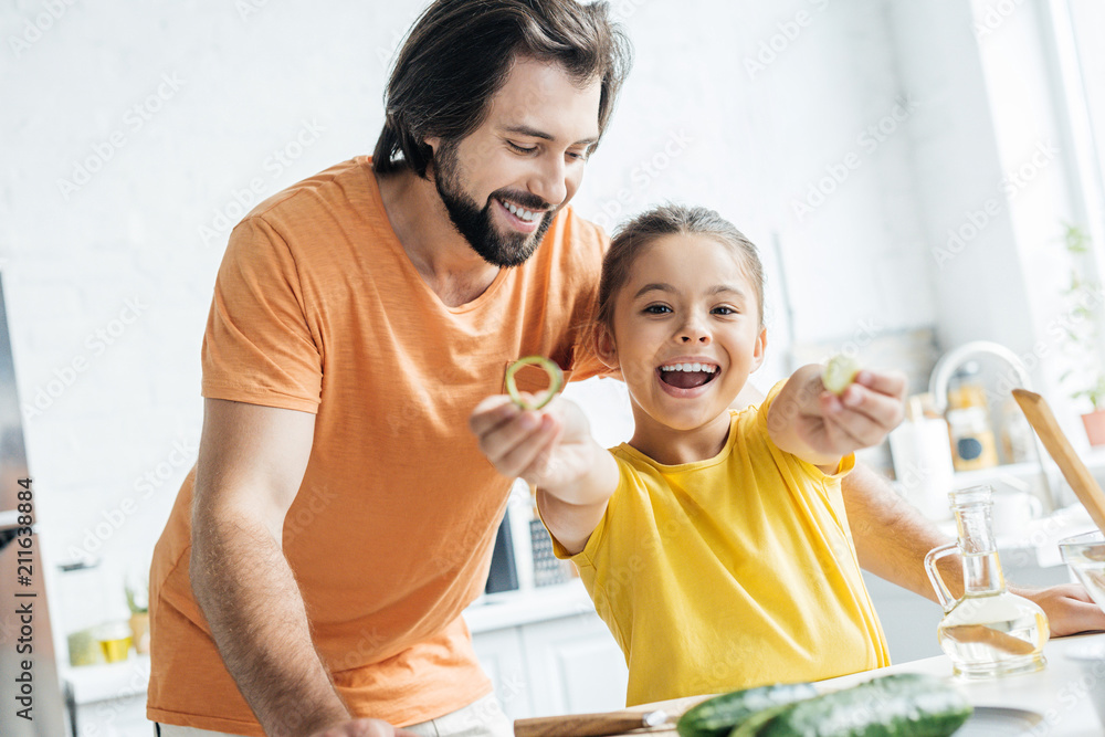 father and daughter having fun at kitchen while cooking father and daughter having fun at kitchen while cooking