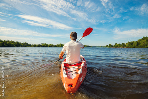 Happy adult man kayaking on the river