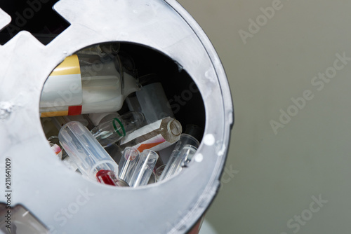 Broken vial of used drug in bioharzard container