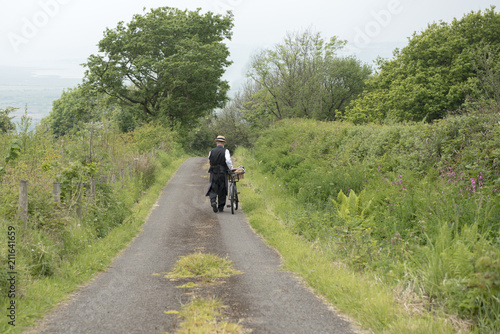 Rear view of a 1940 delivery man on a country road rural setting 