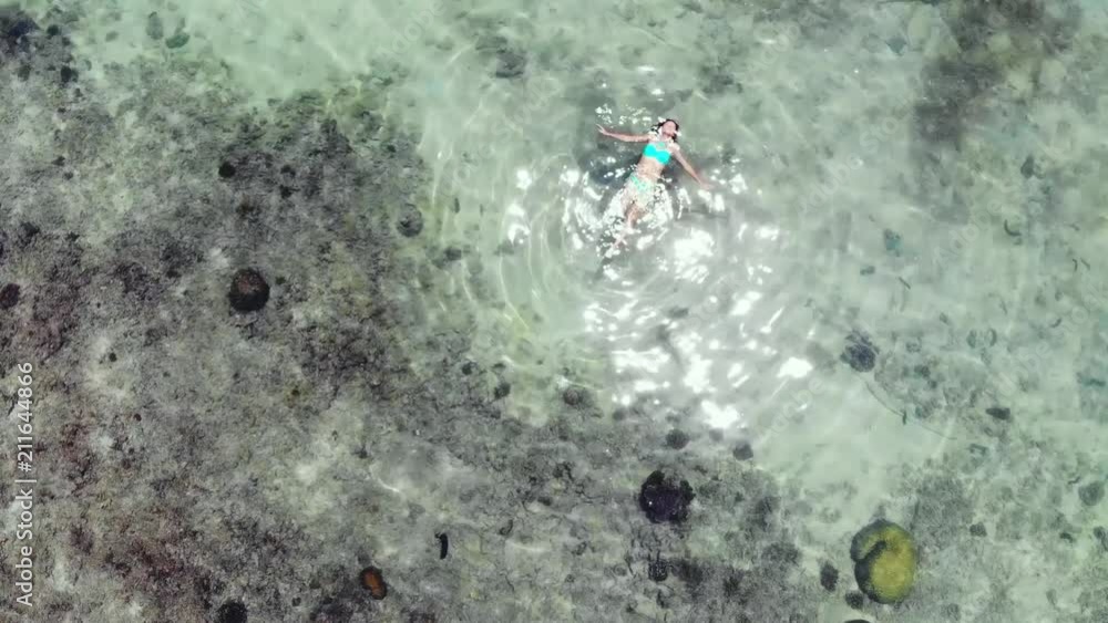 Aerial view of woman floating in amazing clear waters on tropical island. Beautiful sunshine reflected in the sea. 1920x1080 Aerial view of woman floating in amazing clear waters on tropical island. Beautiful sunshine reflected in the sea. 1920x1080