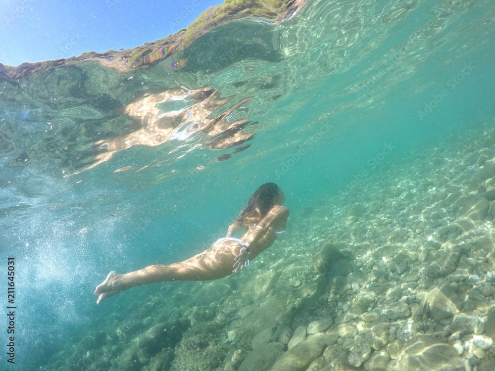 Chica buceando en mar de aguas cristalinas