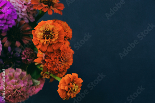 Colorful Zinnias in flower arrangement view from above on black background. Space for text or copy for graphic.