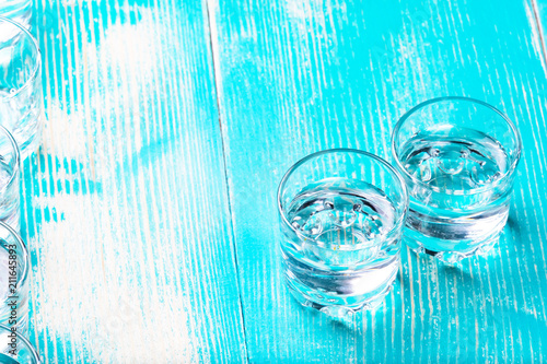 on a blue wooden table are two piles of vodka
