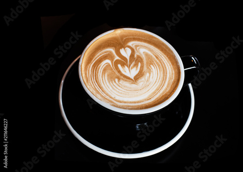 The cappuccino in black ceramic cup,on black table