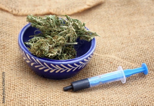 Hash oil phoenix tears medicine in little syringe with dry marijuana buds
