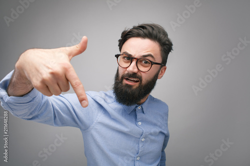 Bully man in glasses gesturing at camera photo