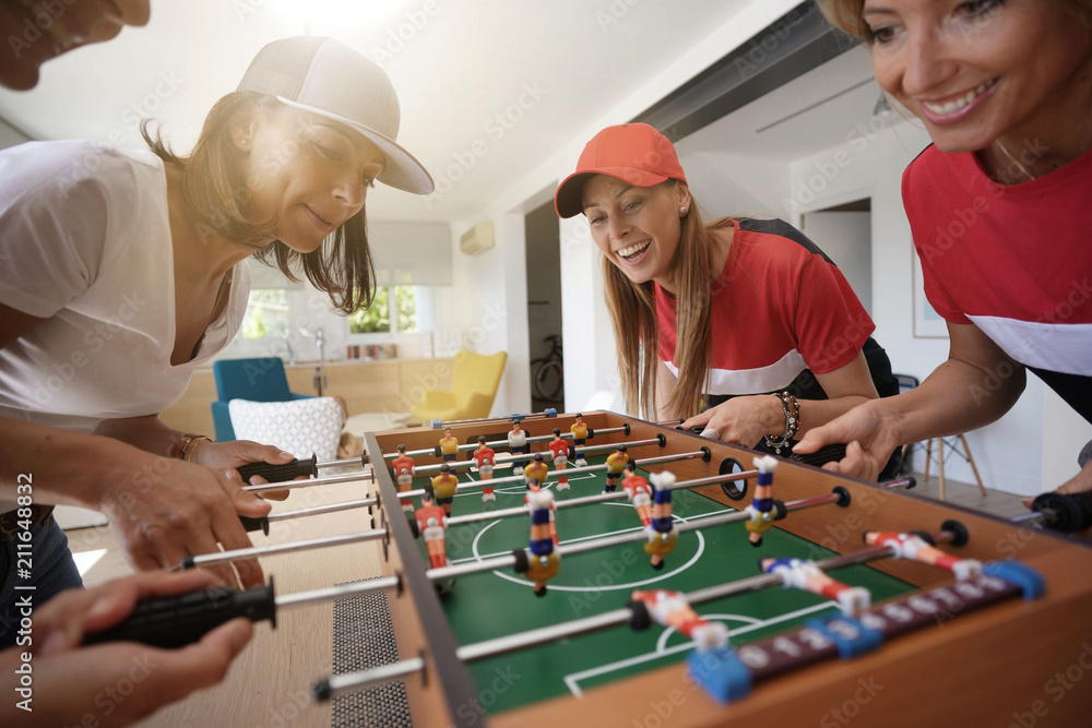 Fototapeta premium Girls having fun playing foosball at home
