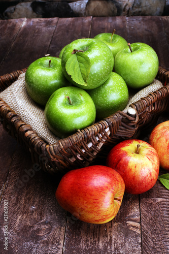 Ripe red apples and green apple on wooden background