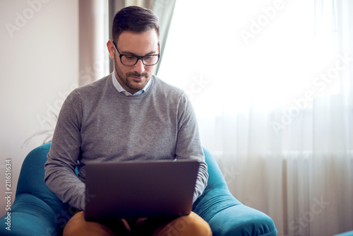 Handsome man working at home in a living room