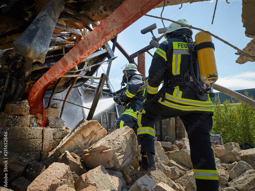 Fototapeta premium Feuerwehr - Feuerwehrmänner löschen Brand 