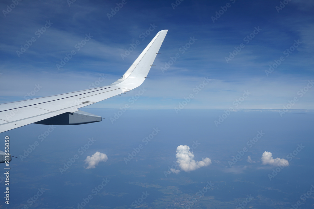 Fototapeta premium Three clouds and airplane wing.
