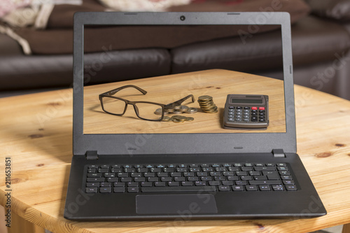 laptop taschenrechner brille und stapel geld