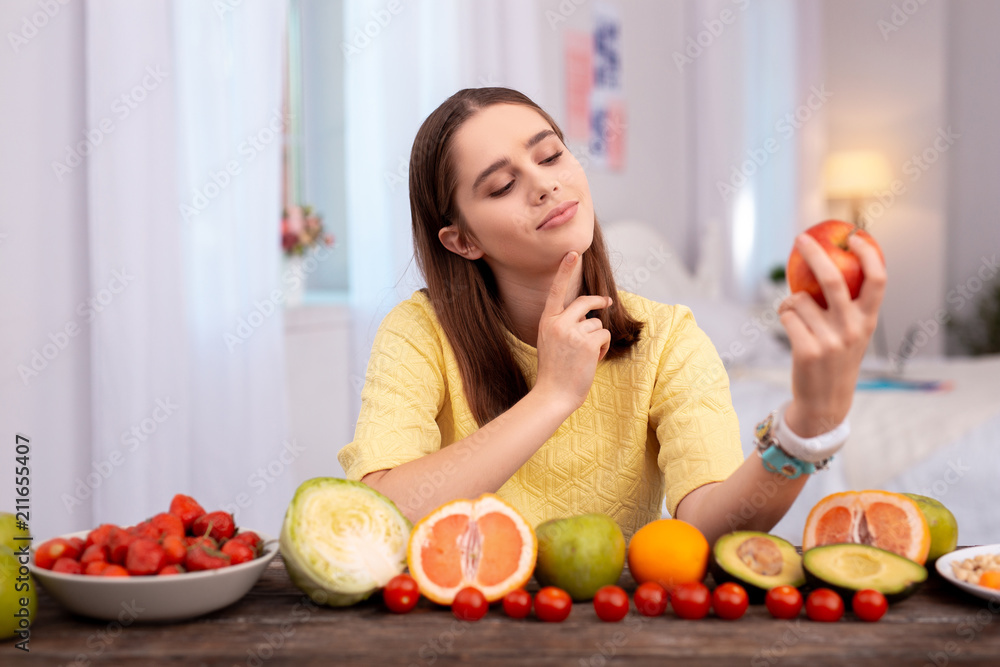 Apple per day. Musing teen girl admiring apple and smiling Apple per day. Musing teen girl admiring apple and smiling