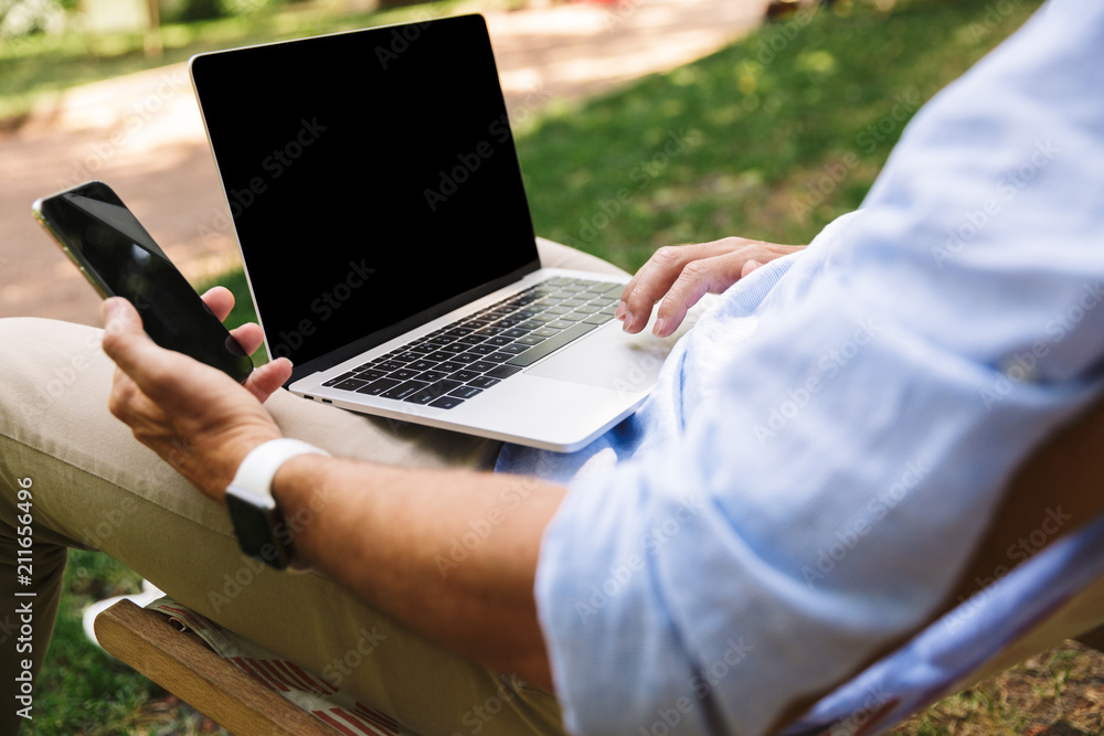 Young man using laptop computer and mobile phone. Young man using laptop computer and mobile phone.