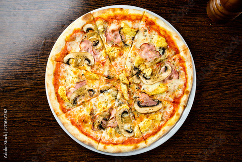 Tasty warm pizza with bacon, mushrooms, cheese and onions on the
