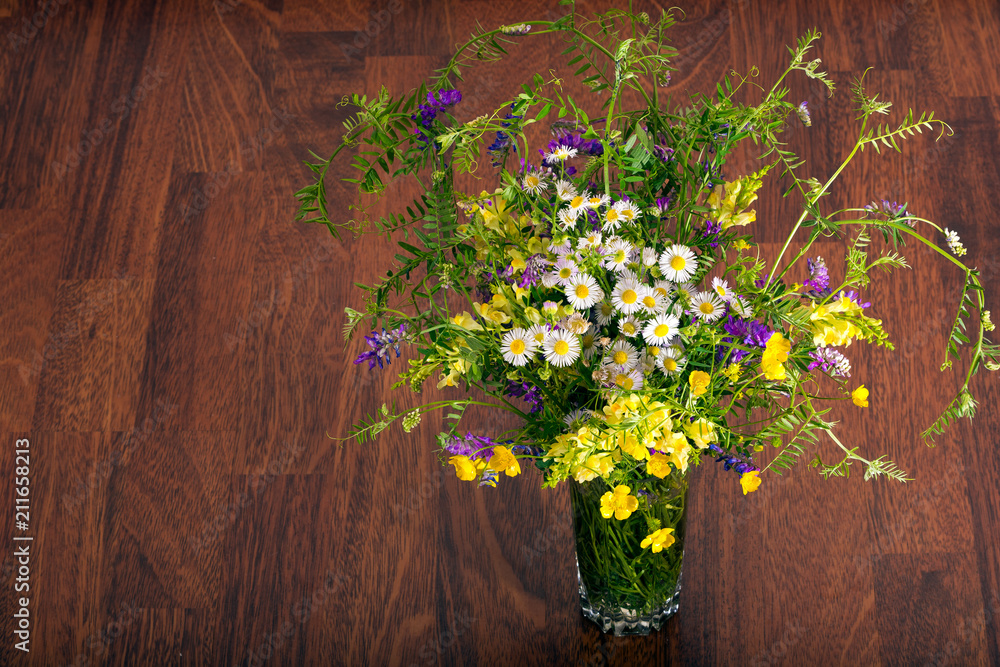 bouquet of wildflowers on a brown wooden background.